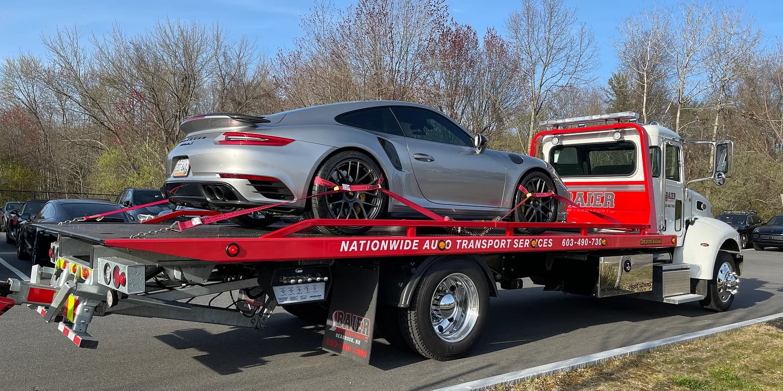 Car shipping insurance — Baier Transport rollback flatbed transporting a high-value Porsche on Nationwide Auto Transport service