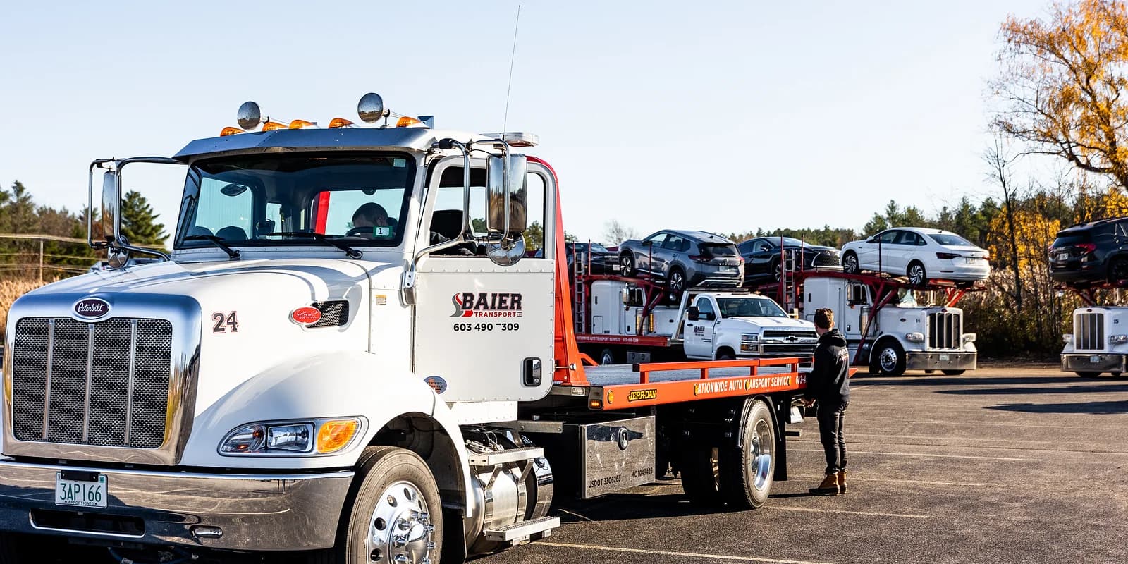 First-time car shipping FAQ — Baier Transport white Peterbilt rollback with red rails ready for a single-vehicle pickup