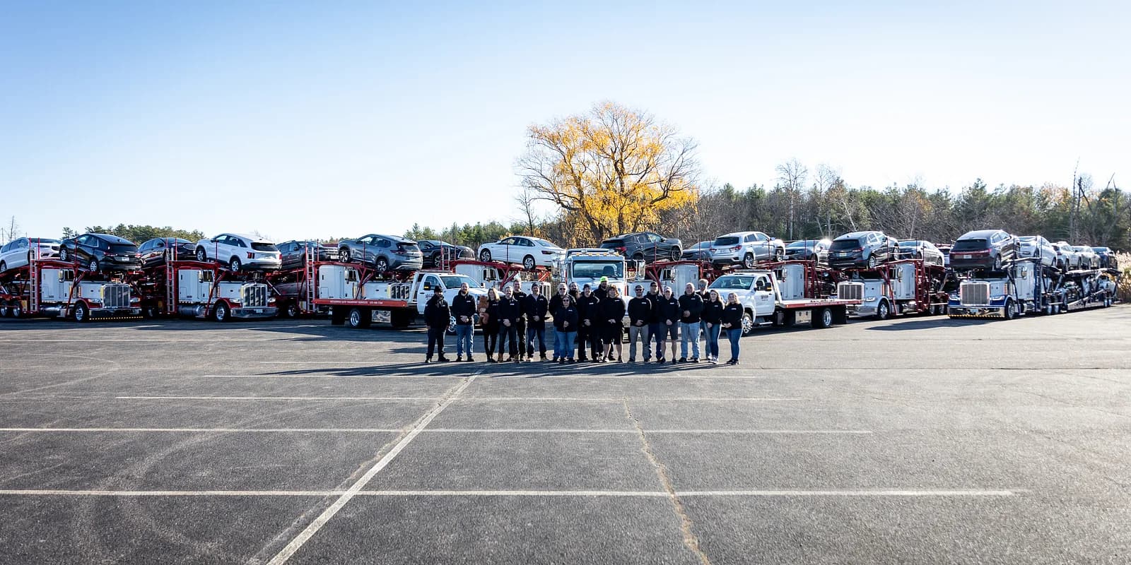 Open vs enclosed auto transport — Baier Transport mixed fleet of open multi-car haulers and a rollback flatbed staged side by side