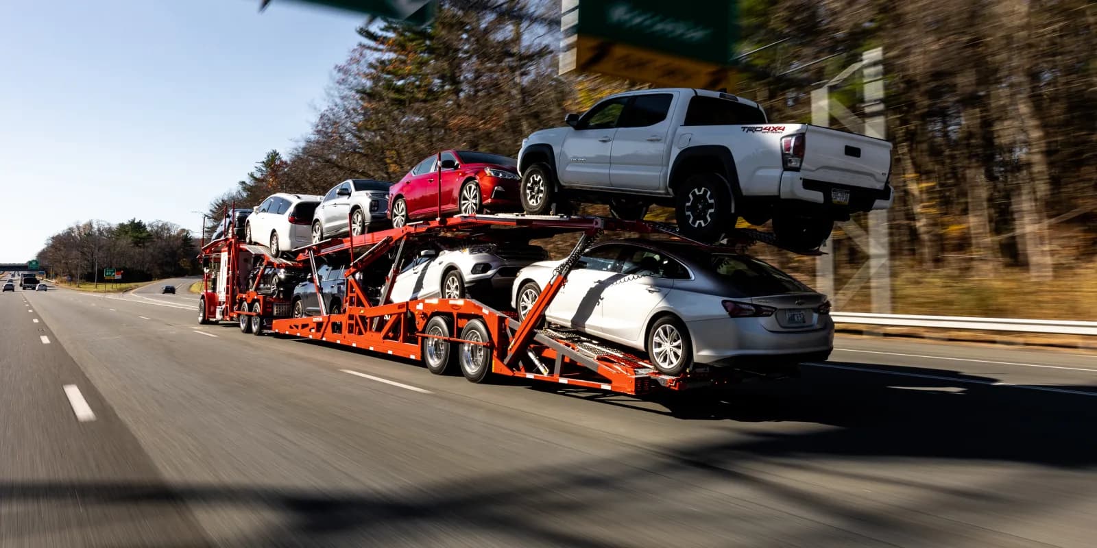 Baier Transport open car carrier loaded with pickups and sedans on the highway