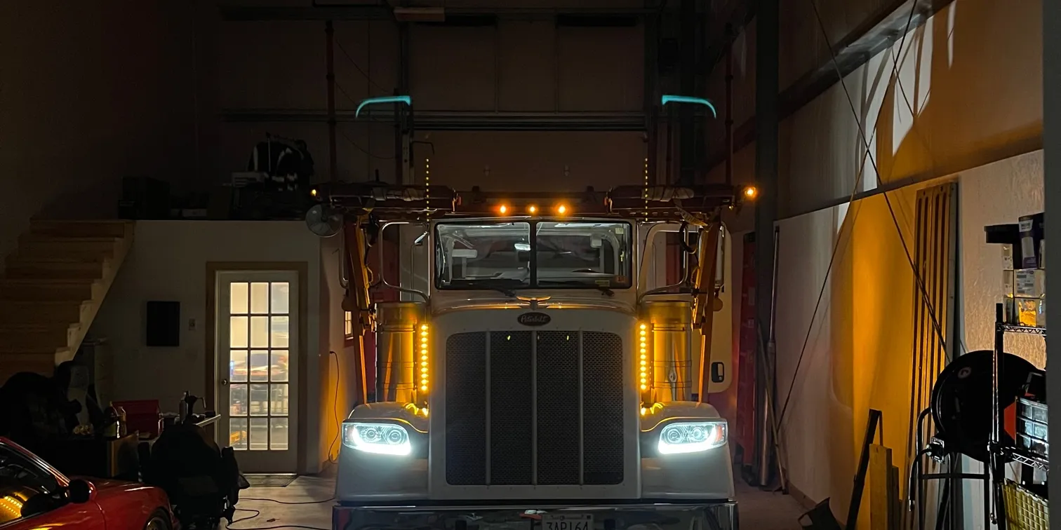 Baier Transport Peterbilt truck with its lights on inside the Seabrook shop