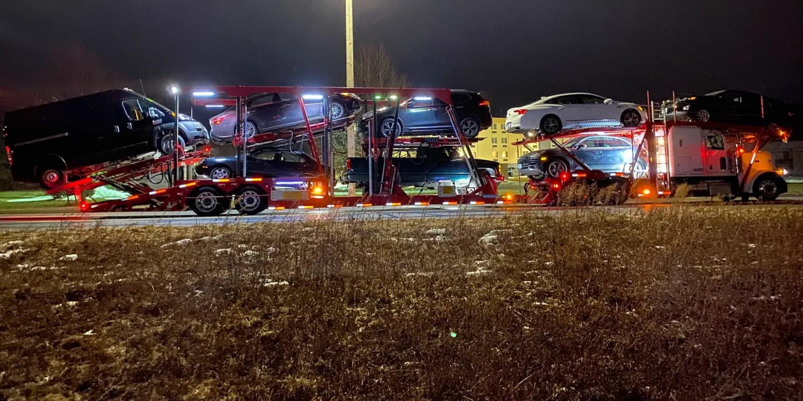 Baier Transport car carriers loading at night under the yard lights