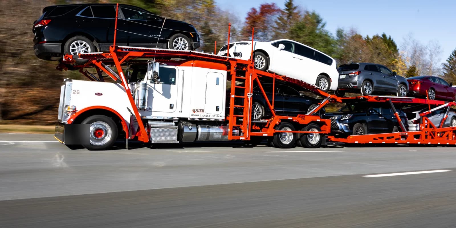 Baier Transport Peterbilt car carrier loaded with SUVs and sedans on the highway