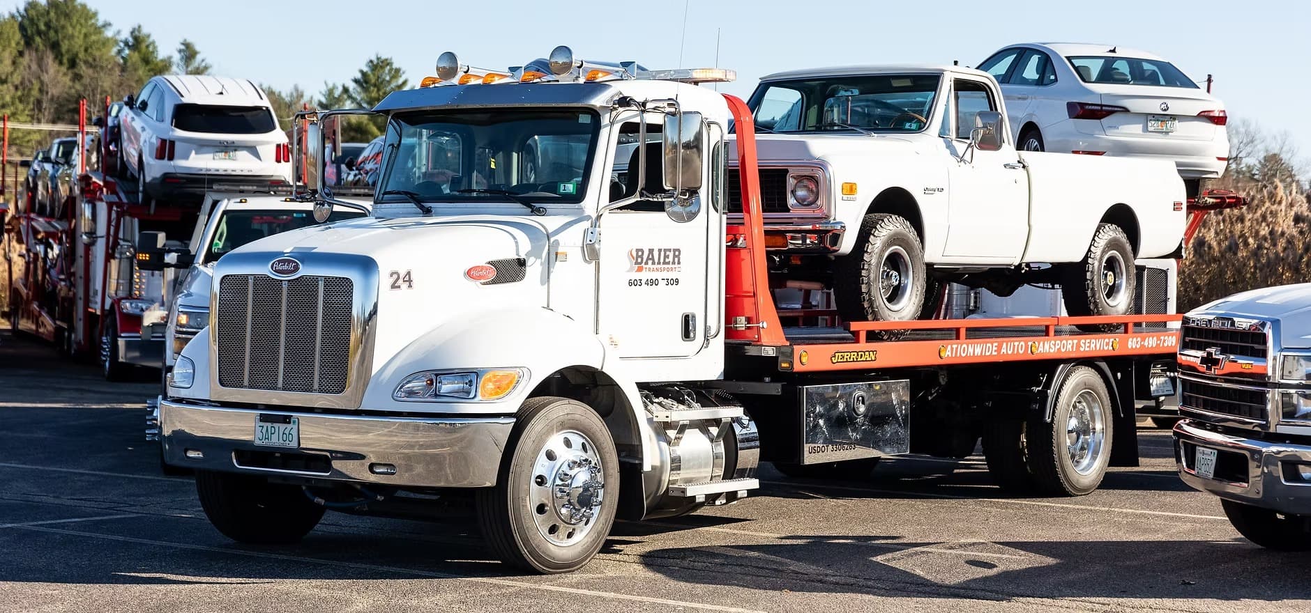 Baier Transport flatbed truck at auction lot ready for vehicle pickup
