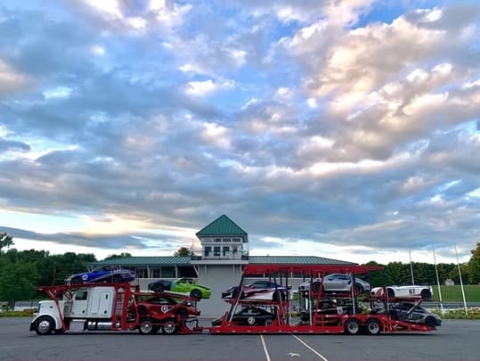 Car carrier loaded with race cars — fully insured vehicle transport by Baier Transport