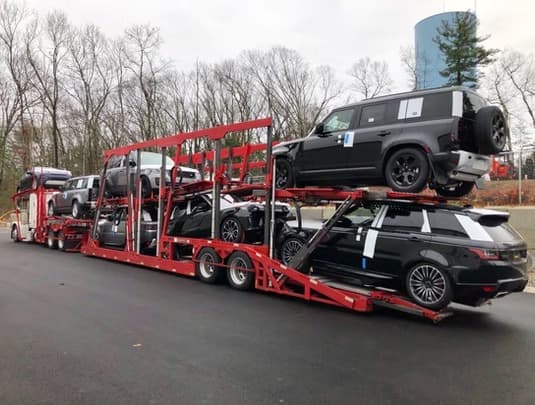 Range Rover and Land Rover on open carrier — first-time vehicle shipping guide by Baier Transport
